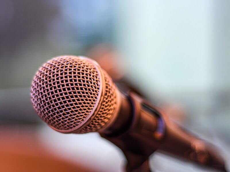 grey microphone on brown wooden stand